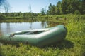 Rubber boat with fishing gear standing on a river near the sandy beach Royalty Free Stock Photo