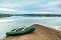 Rubber boat on a gentle sandy shore near the river Royalty Free Stock Photo