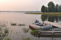 A rubber boat is moored off the shore of a calm evening lake Royalty Free Stock Photo