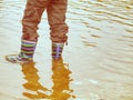 Rubber boots in the muddy water puddle, wavy water level Royalty Free Stock Photo