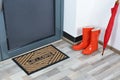 Rubber boots, umbrella and mat near door Royalty Free Stock Photo