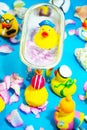 Rubber duck in the bathtub, colorful background with shells, rose petals and other rubber ducks, rubber ducks