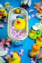 Rubber duck in the bathtub, colorful background with shells, rose petals and other rubber ducks, rubber ducks