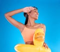 Rubber duck, smile and salute with a swimmer woman in studio on blue background wearing goggles on her head. Happy, hand