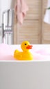Rubber duck toy floating in a bubble bath, bath tub in a bathroom setting Royalty Free Stock Photo
