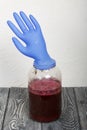 A rubber glove on a can of fermenting grape juice. I was puffed up by the gases released during fermentation. Homemade wine at