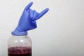 A rubber glove on a can of fermenting grape wine. Inflated from fermentation gases. The fingers are bent in a Sign of the horns.