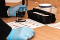 rubber-gloved detective takes fingerprints from surfaces at a crime scene.