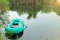 Rubber inflatable boat with oars in the lake on a summer morning in the wild.