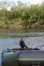 Rubber inflatable boat on the river bank. A fragment of a boat with fishing gear is visible Royalty Free Stock Photo