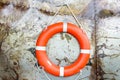 Rubber ring hang on the Steel wall. Orange life saving rubber. Red lifebelt on wall near the ocean. Lifebuoy or lifeguard in the b Royalty Free Stock Photo