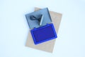 Rubber stamp and Blue Ink cartridges on brown book against white background