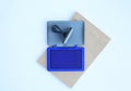 Rubber stamp and Blue Ink cartridges on brown book against white background Royalty Free Stock Photo