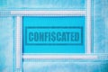 Rubber stamp with text confiscated in an abstract frame made of medical masks on a classic blue background