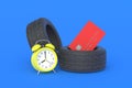 Rubber tyre near credit card and alarm clock. The cost of replacing car wheels