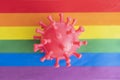 rubber virus lies on the rainbow flag. The concept of the risk of contracting a virus