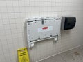 A rubbermaid baby diaper changing station in a restroom