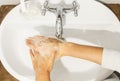 Rubbing big thumb top view, Washing hands with antibacterial soap in proper technique on background of flowing water in white