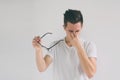 Close up portrait of an attractive man with eyeglasses. Poor young guy has eyesight problems. He is rubbing his nose and Royalty Free Stock Photo