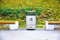 Rubbish bin and bench outdoors. Street in autumn Royalty Free Stock Photo