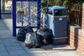 rubbish dumped or fly tipped in the street next to a litter bin