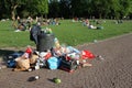 Rubbish next to rubbish bin in park with recreationists Royalty Free Stock Photo