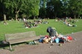 Rubbish next to rubbish bin in park with recreationists Royalty Free Stock Photo