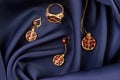 Rubies ring, necklace and earrings on blue silk background with