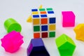 Rubik`s cube and different game color pieces on a white background