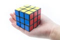 Rubik`s cube is holden by hand isolated on white background Royalty Free Stock Photo