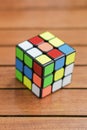 Rubik`s cube on the wooden background. Close up. Copy space banner. Colorful toy on wooden background Royalty Free Stock Photo