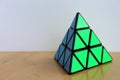 Rubik`s Pyraminx Cube on a Table Royalty Free Stock Photo