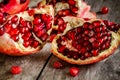 Ruby juicy pomegranate open with seeds closeup on wooden table