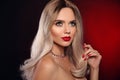 Ruby pendant jewelry. Beauty portrait of blonde woman with red lips, long healthy shiny blond hair style and manicured nails. Royalty Free Stock Photo