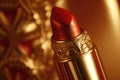 Ruby red lipstick on golden background. Beauty makeup cosmetics for lips. Glamourous fashion tube.