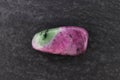Ruby zoisite stone texture on black stone background. Macro closeup Royalty Free Stock Photo