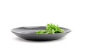 Ruccola or rocket salad leaves on grey plate isolated on white background Royalty Free Stock Photo