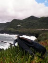 Rucksack on cliffs at Piscinas Naturais Caneiros, travel and nature concept