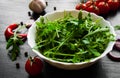 Rucola fresh salad in white bowl on dark wooden background Royalty Free Stock Photo