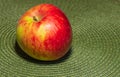 Ruddy apple of irregular shape on a textile napkin