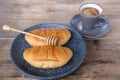 Ruddy fresh croissants on a dark gray plate, sweet honey is pouring in a thin amber stream, fresh baked goods concept, breakfast,