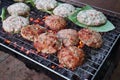 ruddy fried cutlets on a green leaf are fried on the street on a grill. Street food in Asia. Preparing beef cutlet with spices on