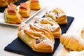 Ruddy pastry, buns sprinkled with powdered sugar lie on long plates of black color.