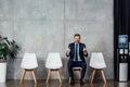 Rude businessman in suit sitting and showing middle fingers in Royalty Free Stock Photo