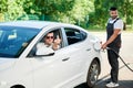 Rude driver showing middle finger to other car on gas station.