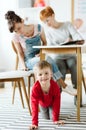 Rude kid sitting under the table during therapy for ADHD with his mother and professional therapist Royalty Free Stock Photo