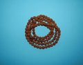 Rudraksha beads rosary top view on the blue background with copy space.