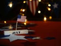 Ruffled American flag and wooden cube calendar with 4th of July, USA Independence Day date, copy space celebratory background. US Royalty Free Stock Photo