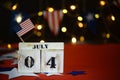 Ruffled American flag and wooden cube calendar with 4th of July, USA Independence Day date, copy space celebratory background. US Royalty Free Stock Photo