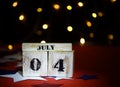 Ruffled American flag and wooden cube calendar with 4th of July, USA Independence Day date, copy space celebratory background. US Royalty Free Stock Photo